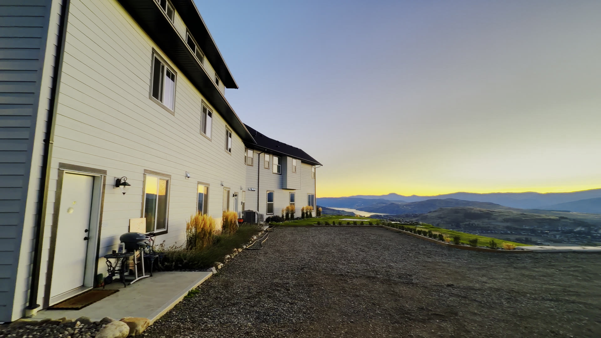 The house along the drive, with the valley and hills behind at sunset