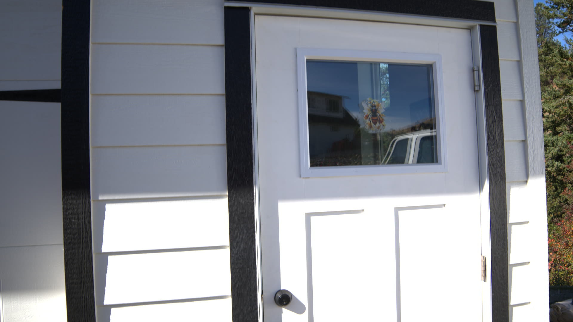 Suite Bee's private entrance: white door in white siding with black trim
