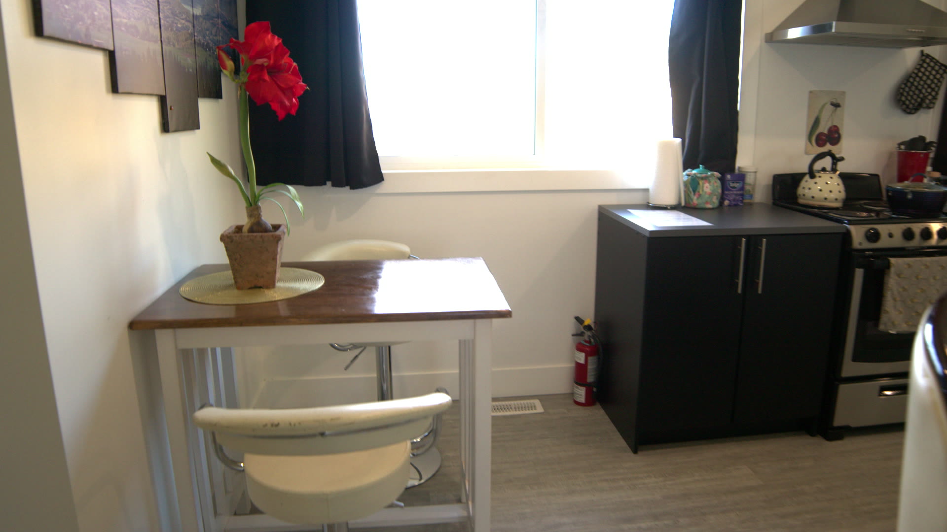 Sitting table with two white chairs and a red amaryllis by the window