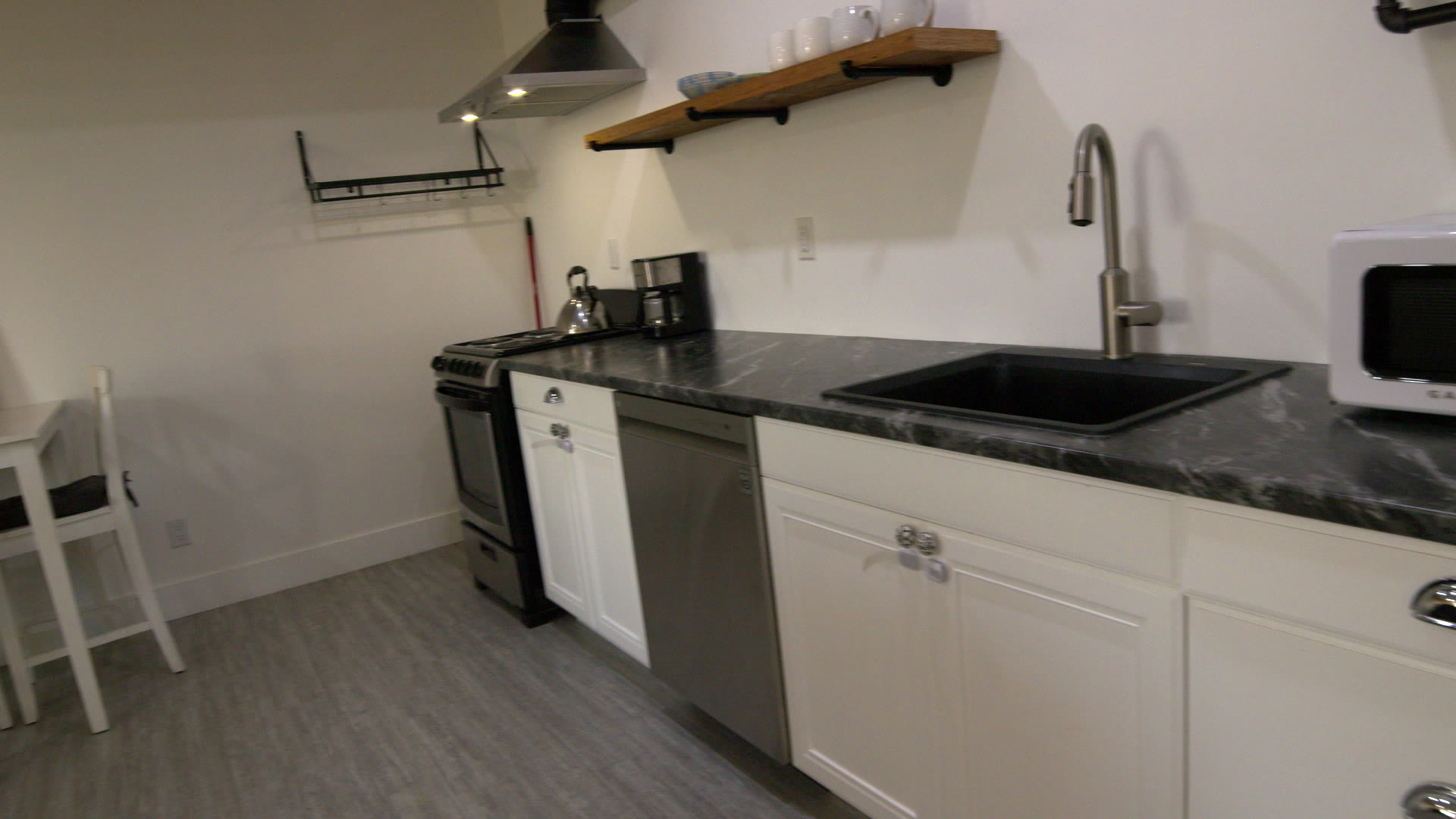 Kitchen: dark counter, white cabinets, stove and dishwasher